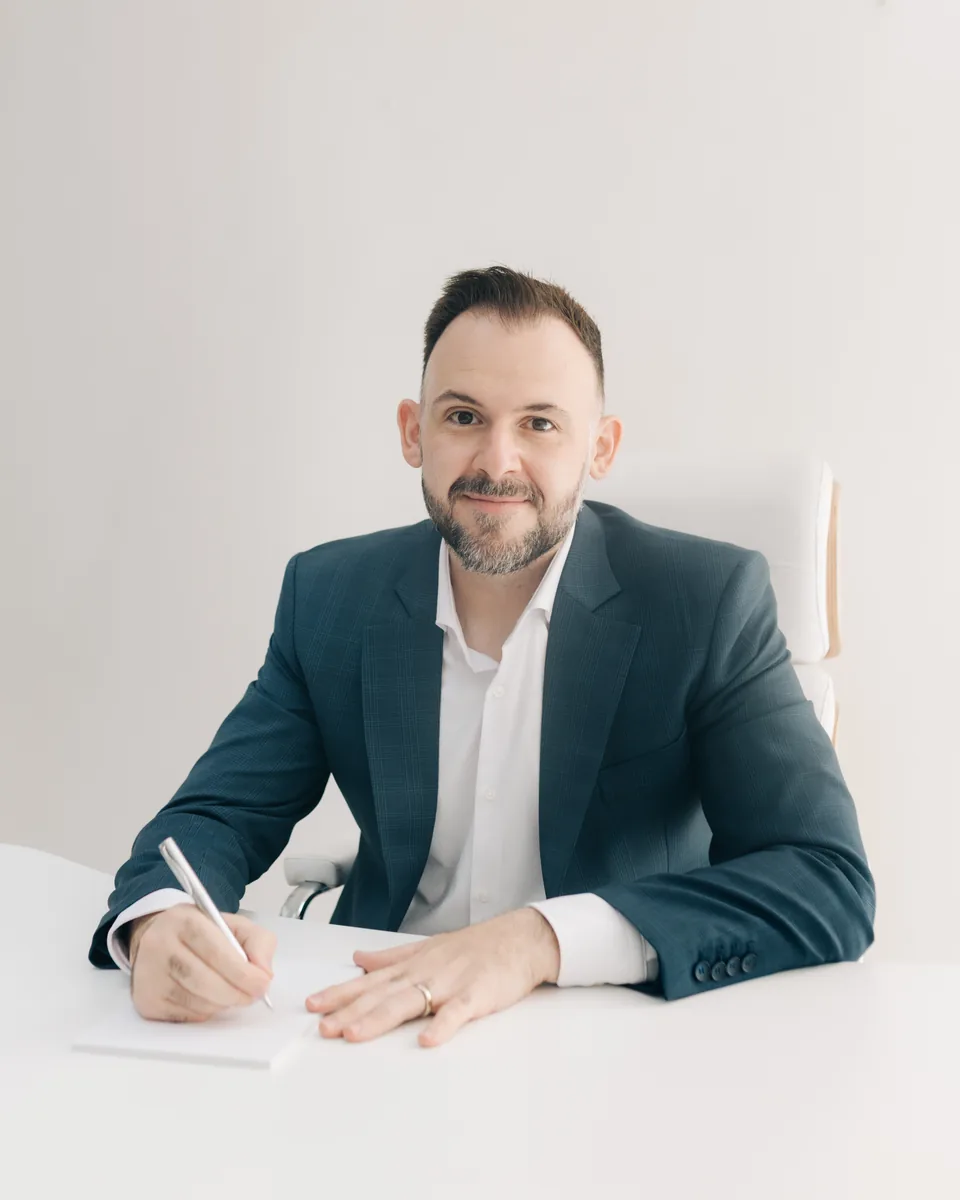 Dr. Antonio Cavani Neto escrevendo à mesa do consultório